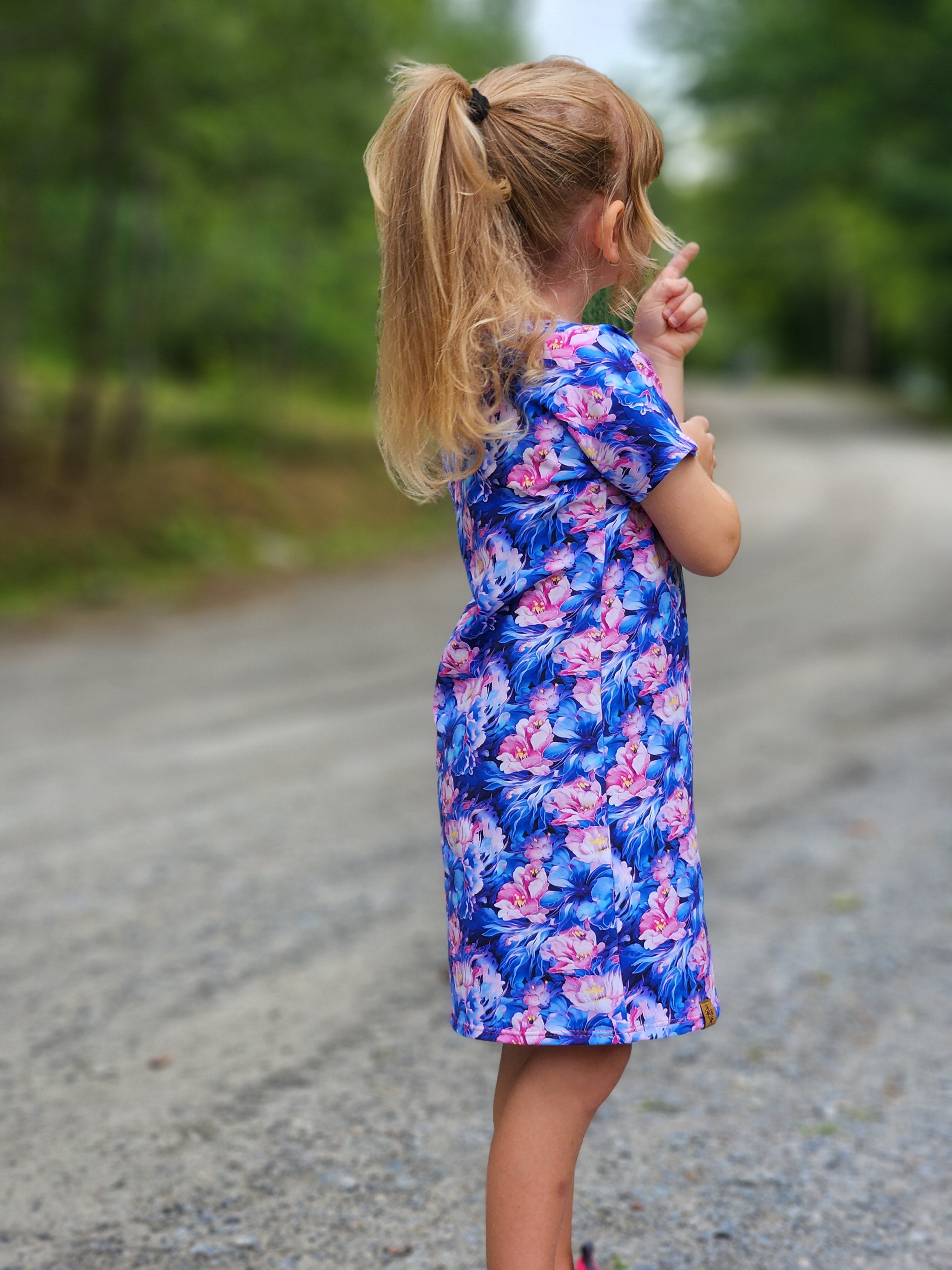Person wearing a floral dress with a blurred background