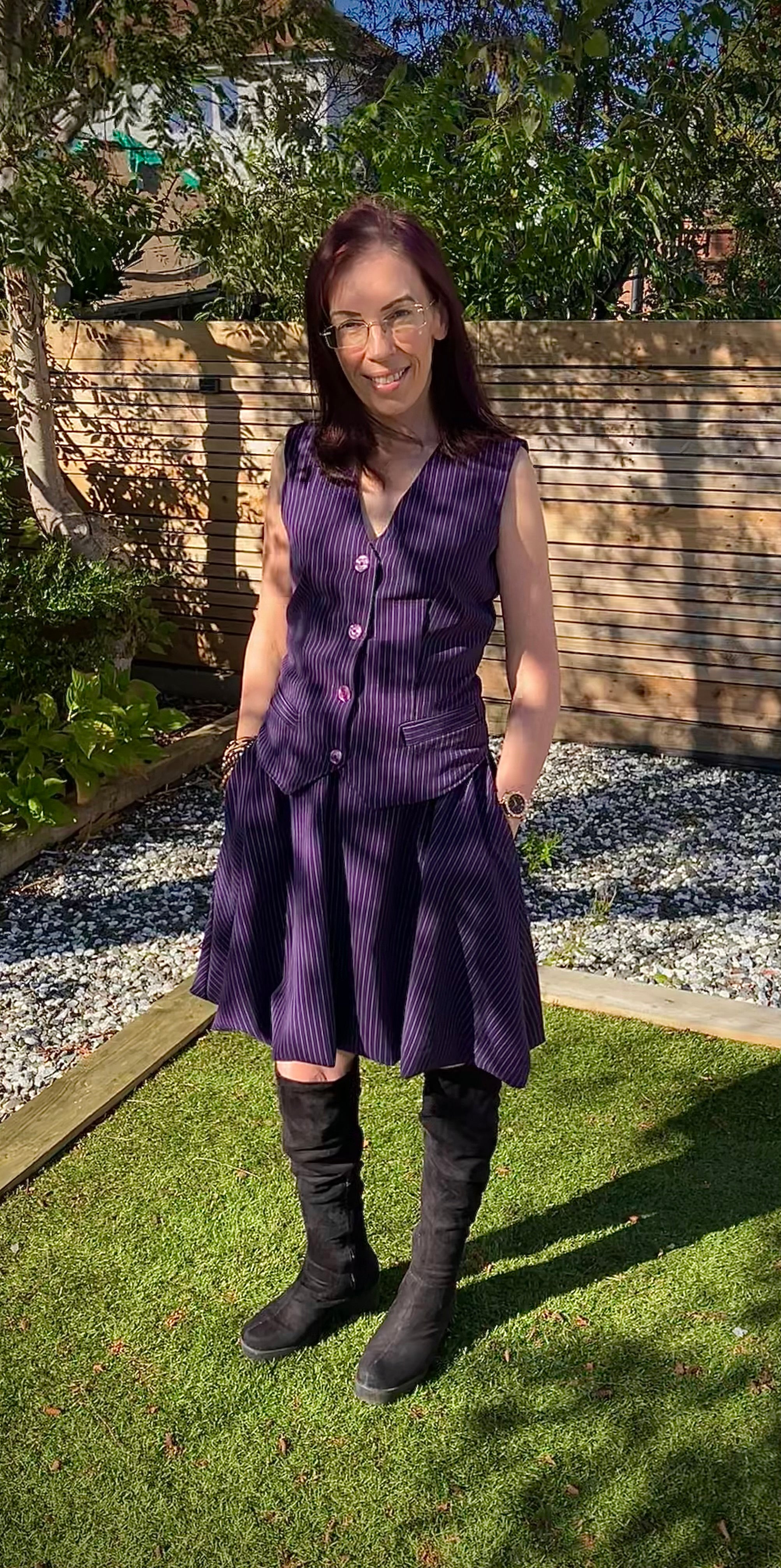 Woman wearing a purple bubble skirt and vest standing in a garden. PDF sewing patterns for sizes xxs - 6xl. Modern sewing patterns.