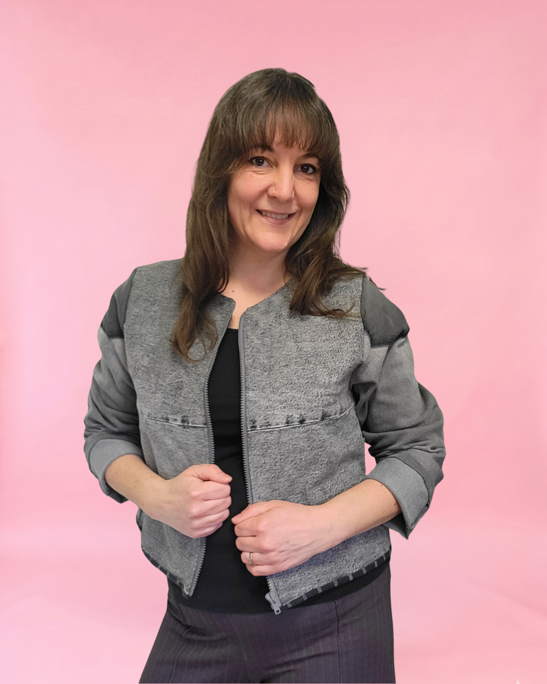 Woman wearing a gray denim jacket against a plain background made using old jeans and the Harper Everyday Jacket sewing pattern.