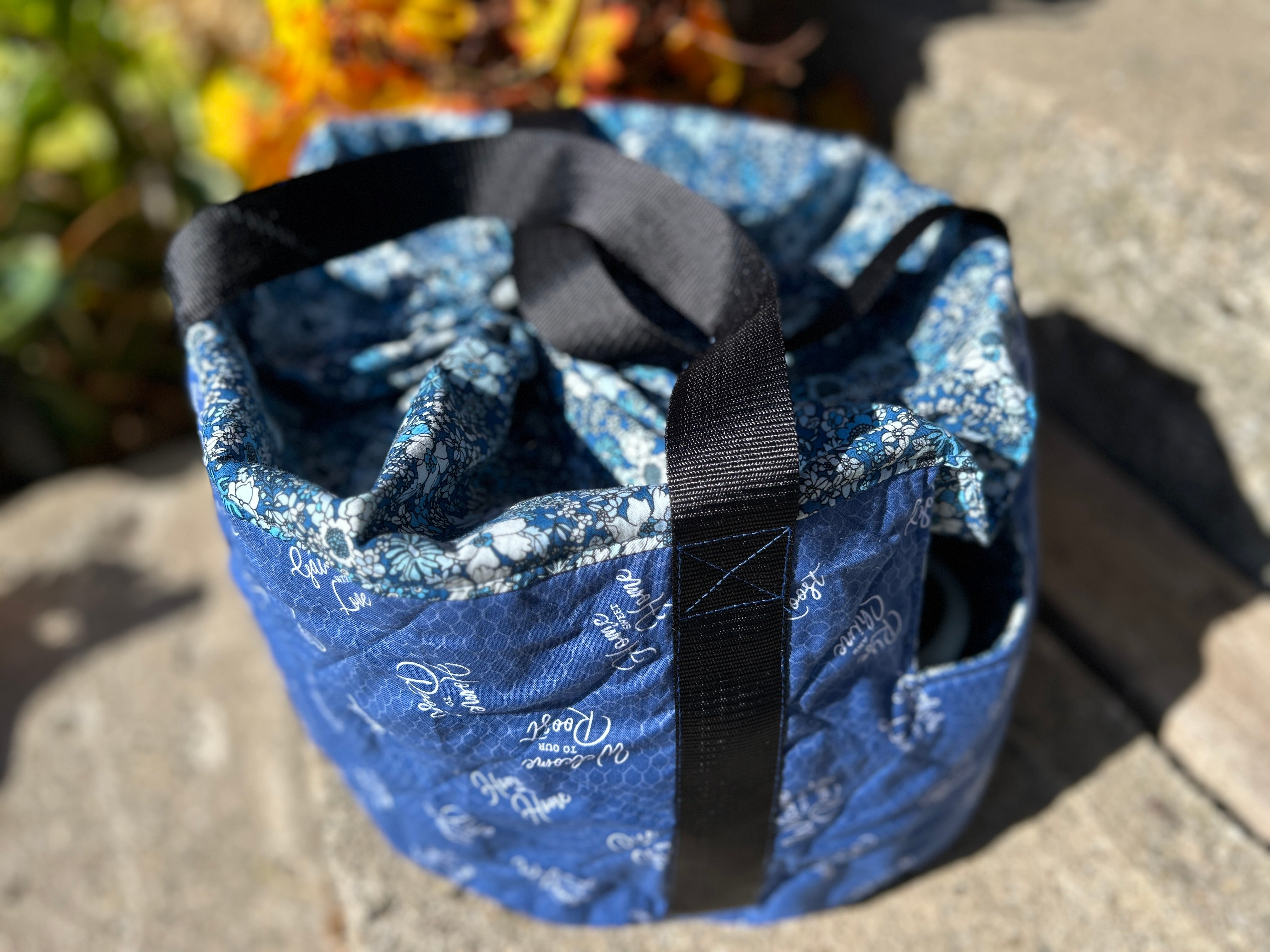 Blue patterned crock pot carrying bag with a black strap on a concrete surface. Easy home decor sewing patterns.
