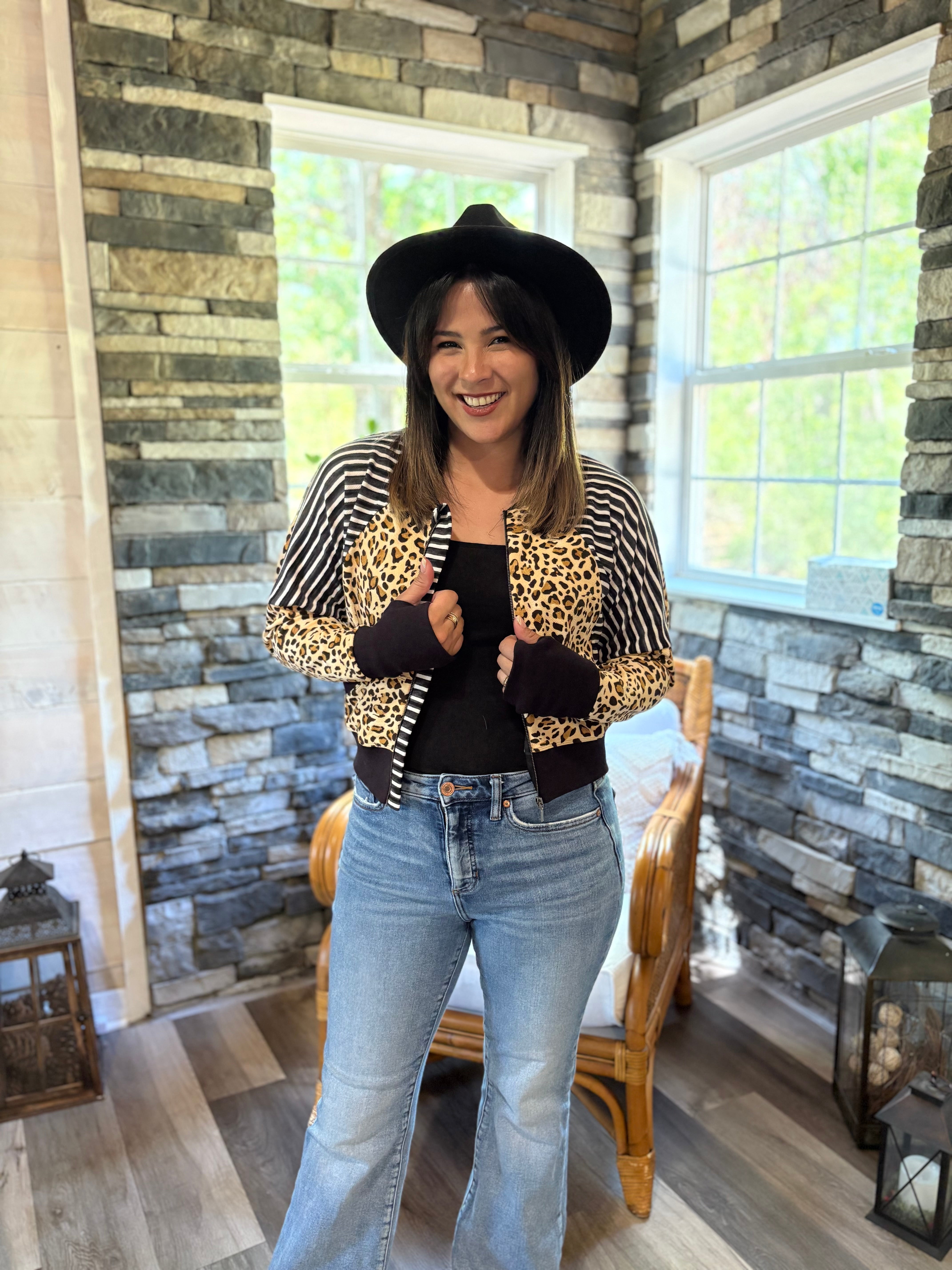 Woman modeling a cheetah print and stripe athletic raglan bomber jacket with zip closure. Solid black Thumbhole cuffs and band. Cropped version. Ellie and Mac PDF sewing patterns.