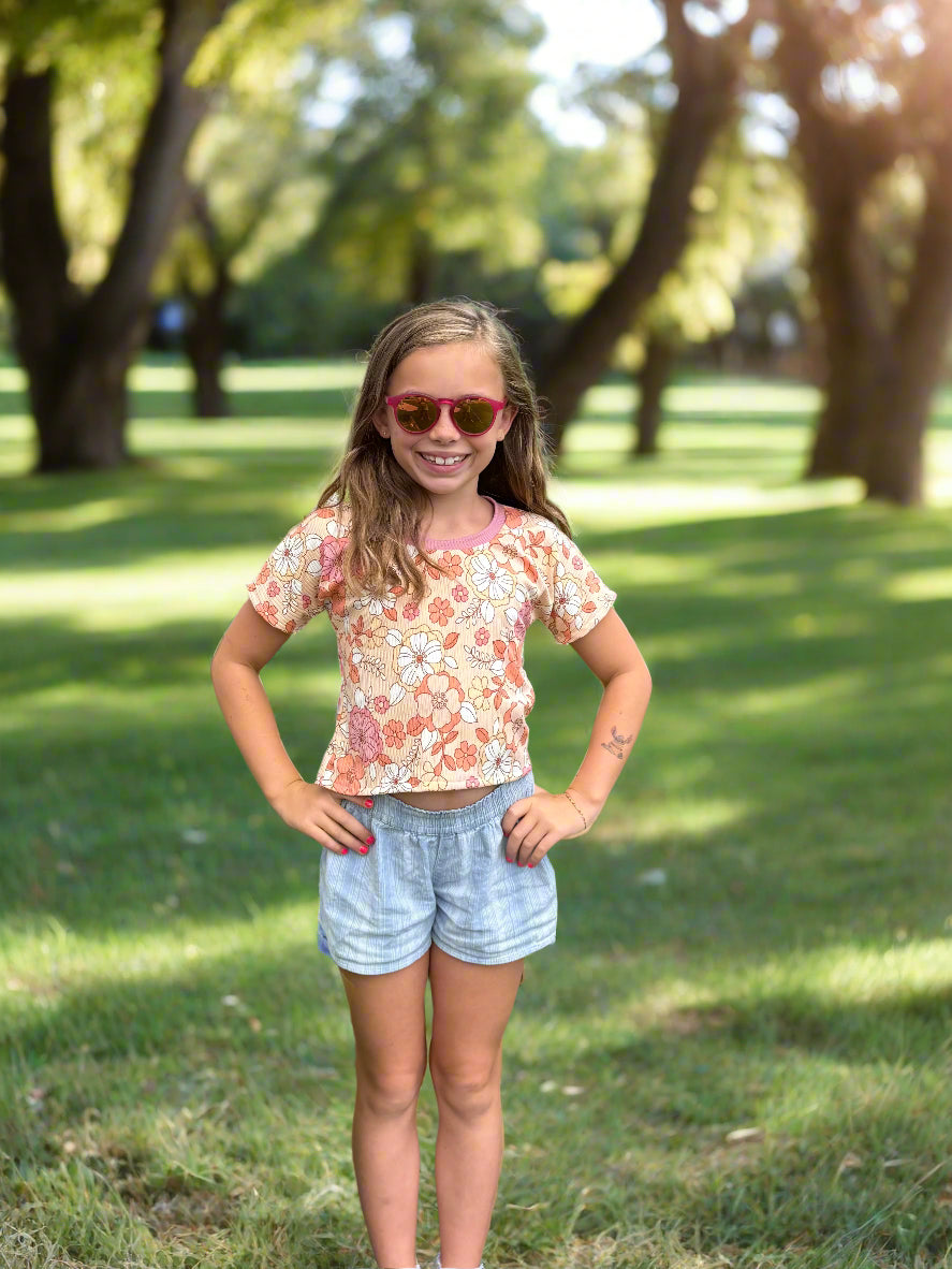 Girl modeling a floral crop top dolman sewing pattern for kids by Ellie and Mac sewing patterns.