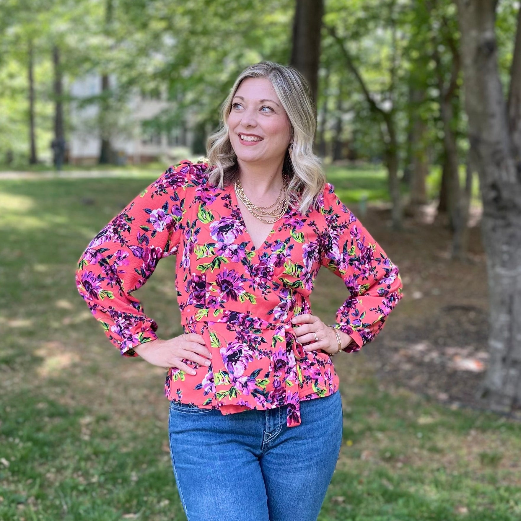Photo of Lindsey Essary Owner and Head Pattern Designer Ellie and Mac Sewing Patterns standing outside wearing an orange floral Leonie wrap top.