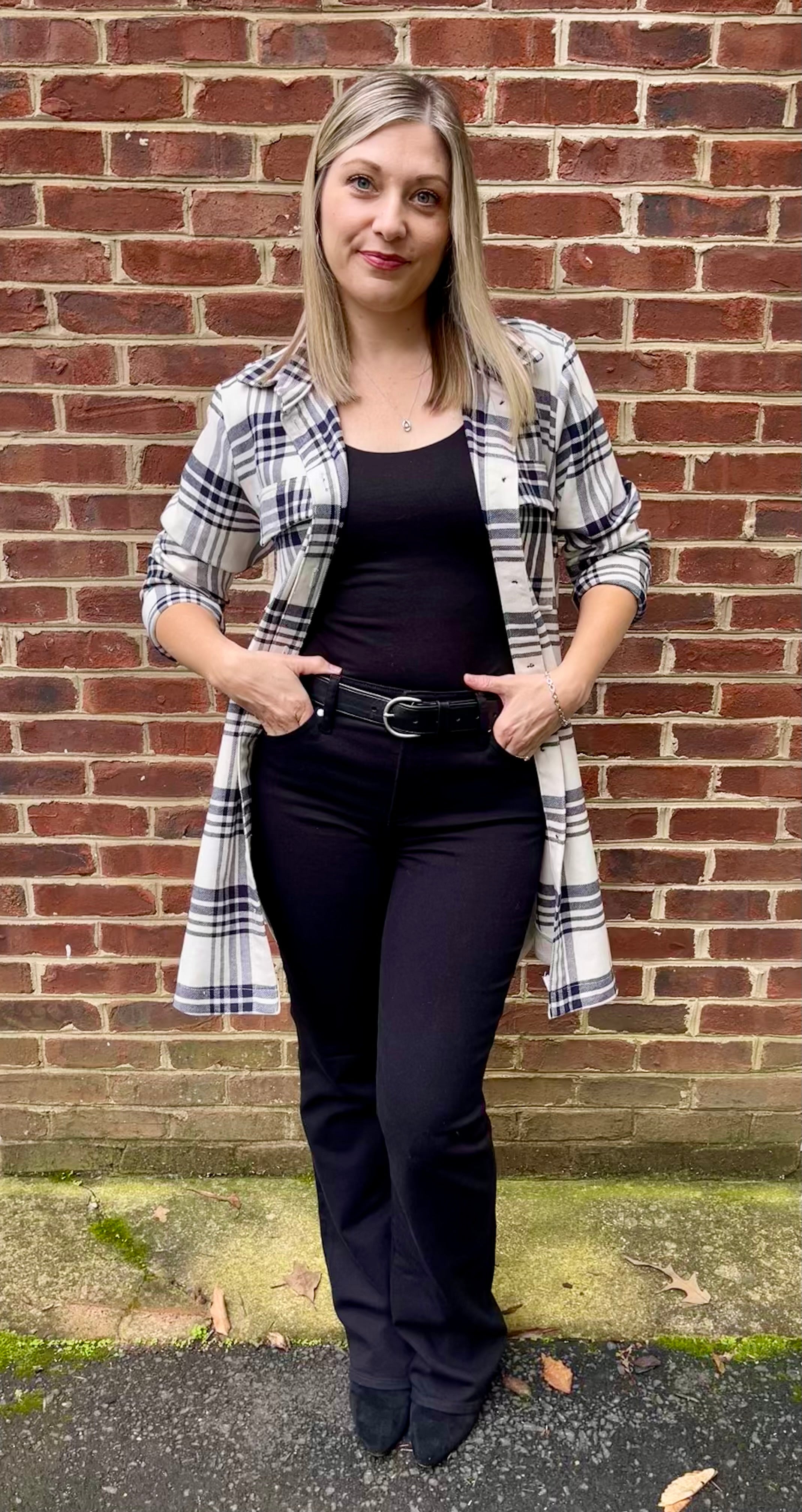 Model has black pants, boots, and a cami worn under a knee length black and white flannel shacket. The shacket is made using the Connie Casual Shacket PDF sewing pattern by Ellie and Mac Sewing patterns.