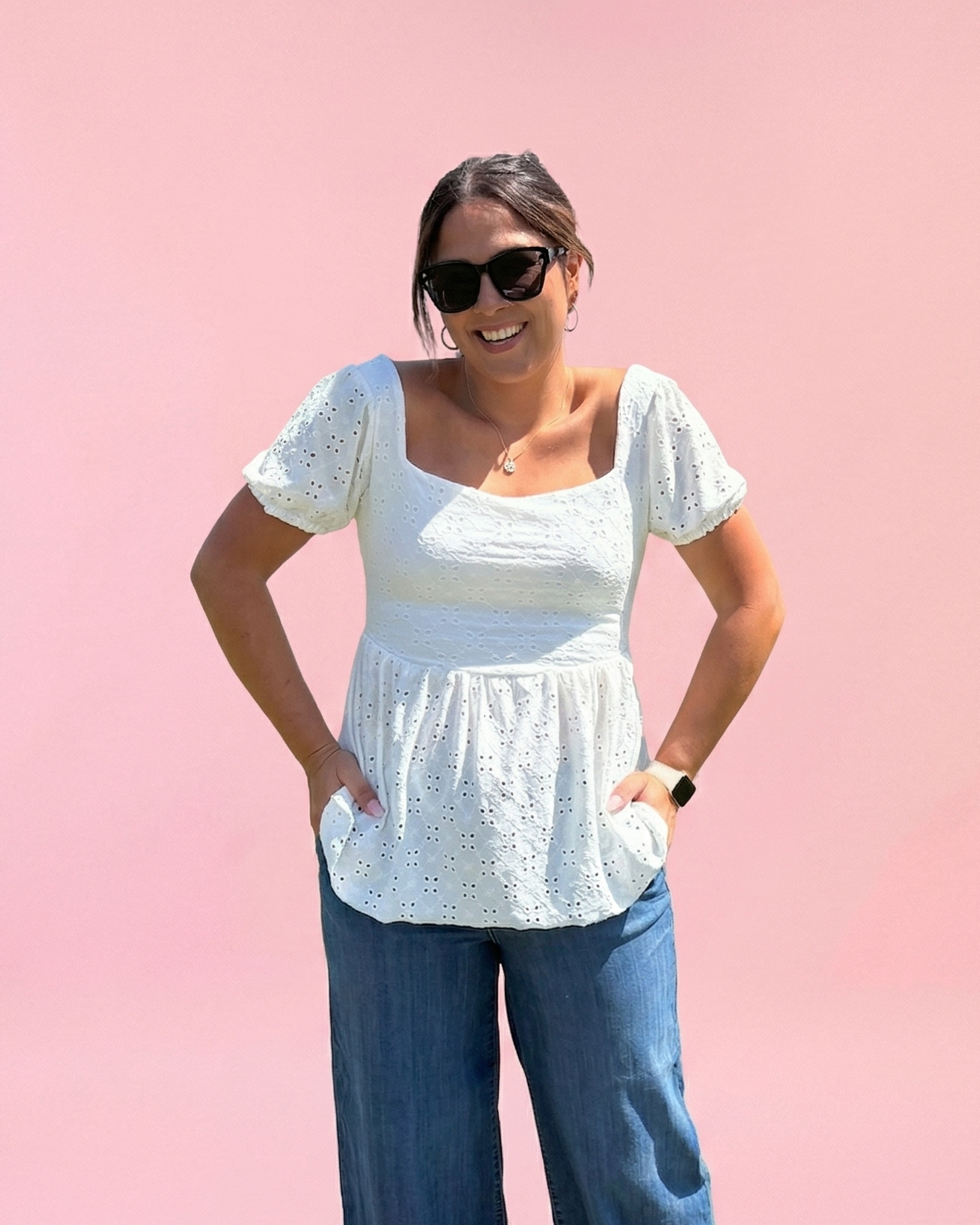 A smiling woman wearing a white knit peplum with a square neckline and tie back detail. Cute sewing pattern for summer.
