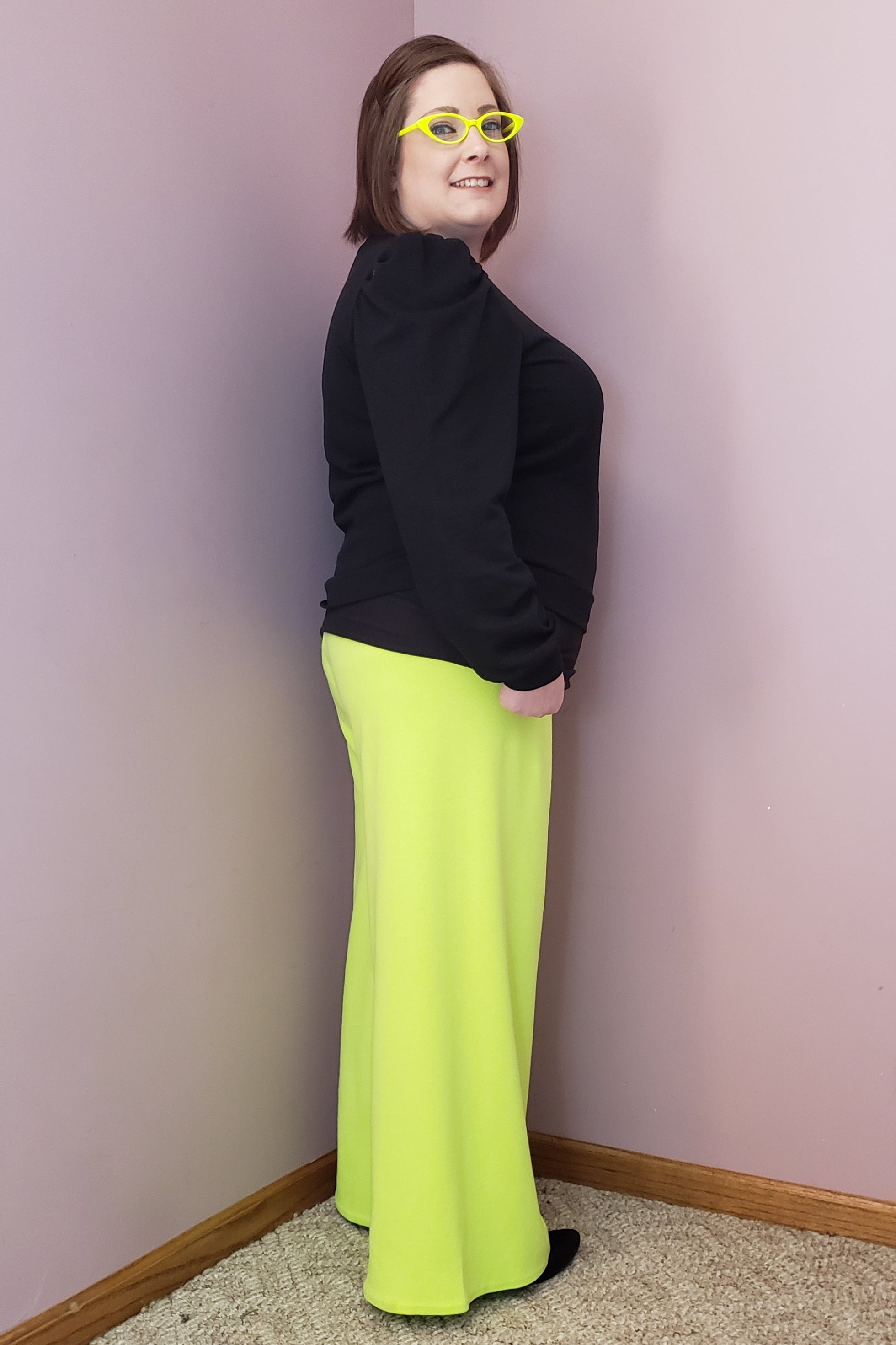 Neon knit pants worn with a black puff sleeve top. Easy sewing pattern for women by Ellie and Mac.