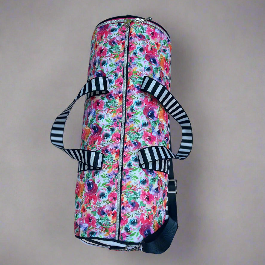 Serena Sports Duffle Bag in a waterproof floral canvas fabric and white and black contrasting bottom panel. Adjustable shoulder straps and hand straps. Side Zipper shoe compartment to keep dirty shoes away from clean clothes. Side mesh pocket for quick access to keys, phone, airpods, and more. Easy PDF sewing pattern by Ellie and Mac Sewing Patterns.