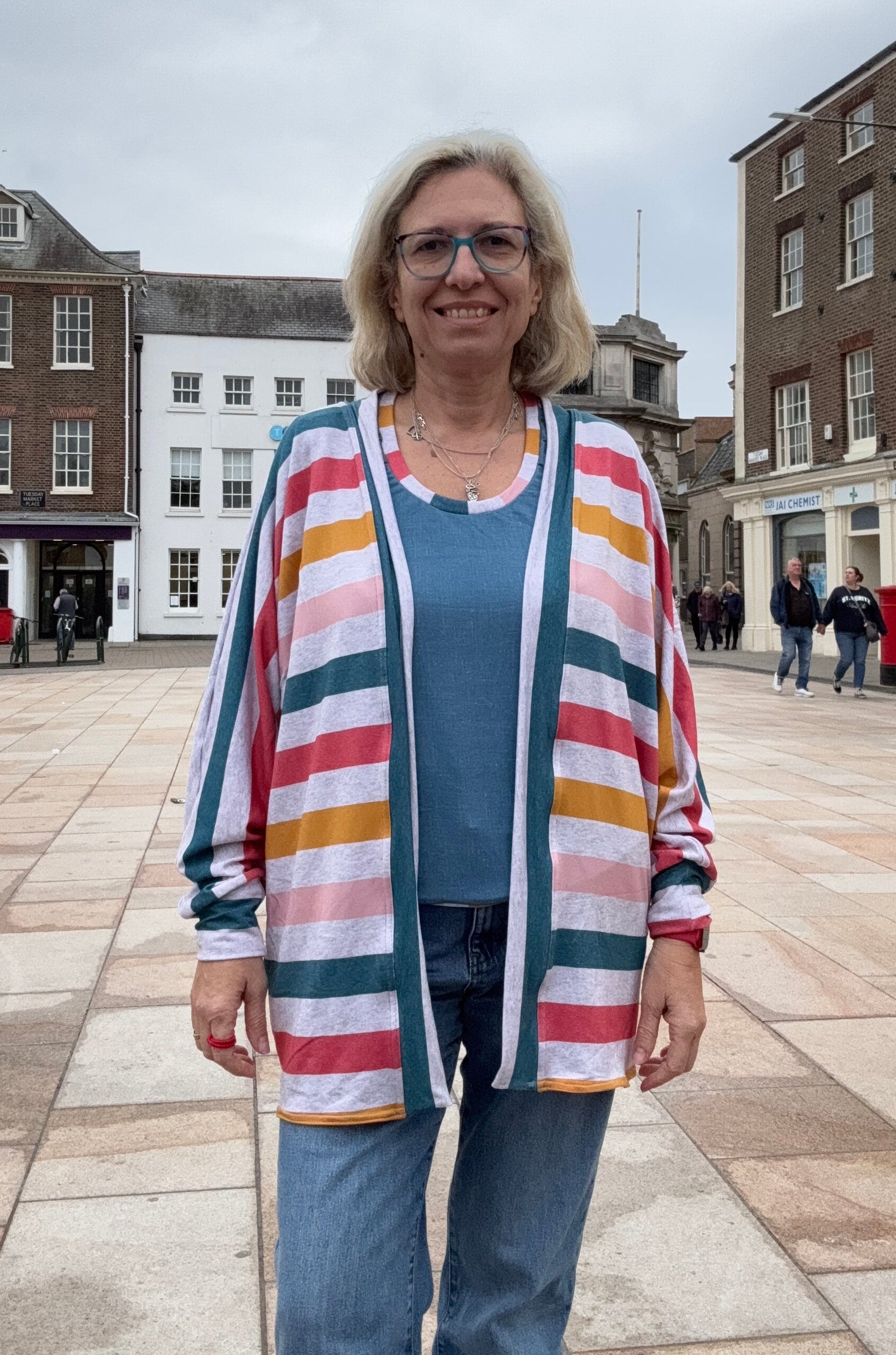 Person wearing a colorful striped sweater batwing cardigan. Easy Sewing patterns for beginners.