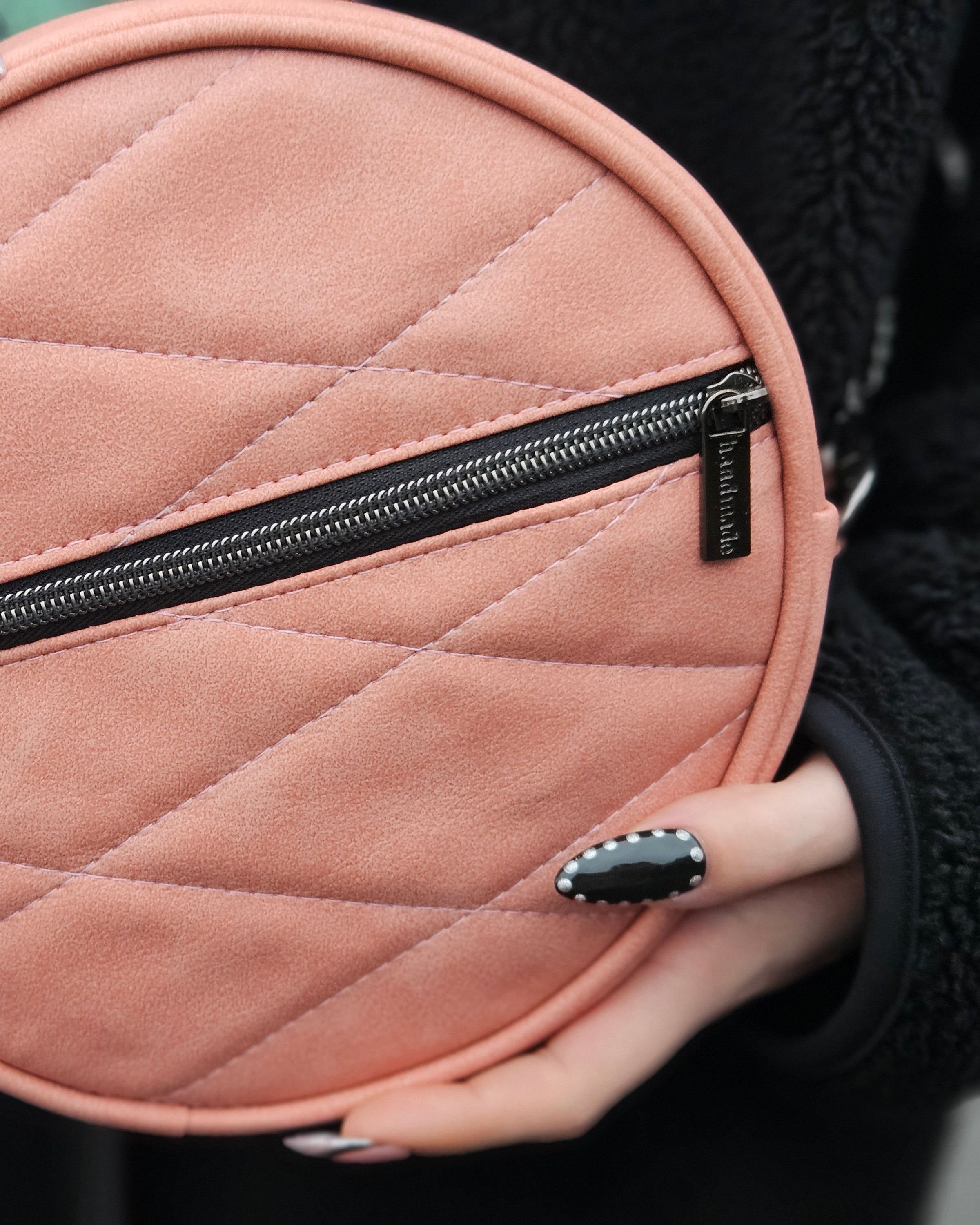 Round pink quilted bag with a zipper held by a person. Made using Ellie and Mac sewing patterns.