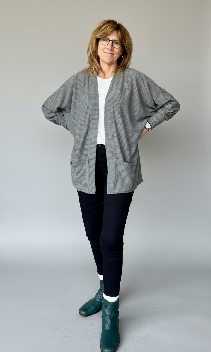 Woman modeling the Celeste Batwing Cardigan PDF sewing pattern in mid-thigh length with pockets.