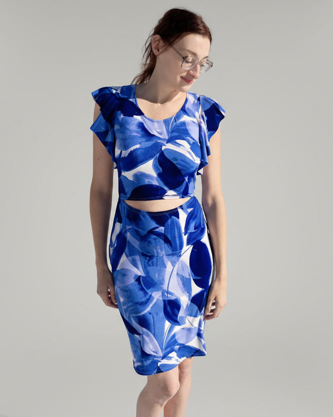 Woman wearing a blue and white patterned dress standing in a snowy landscape.