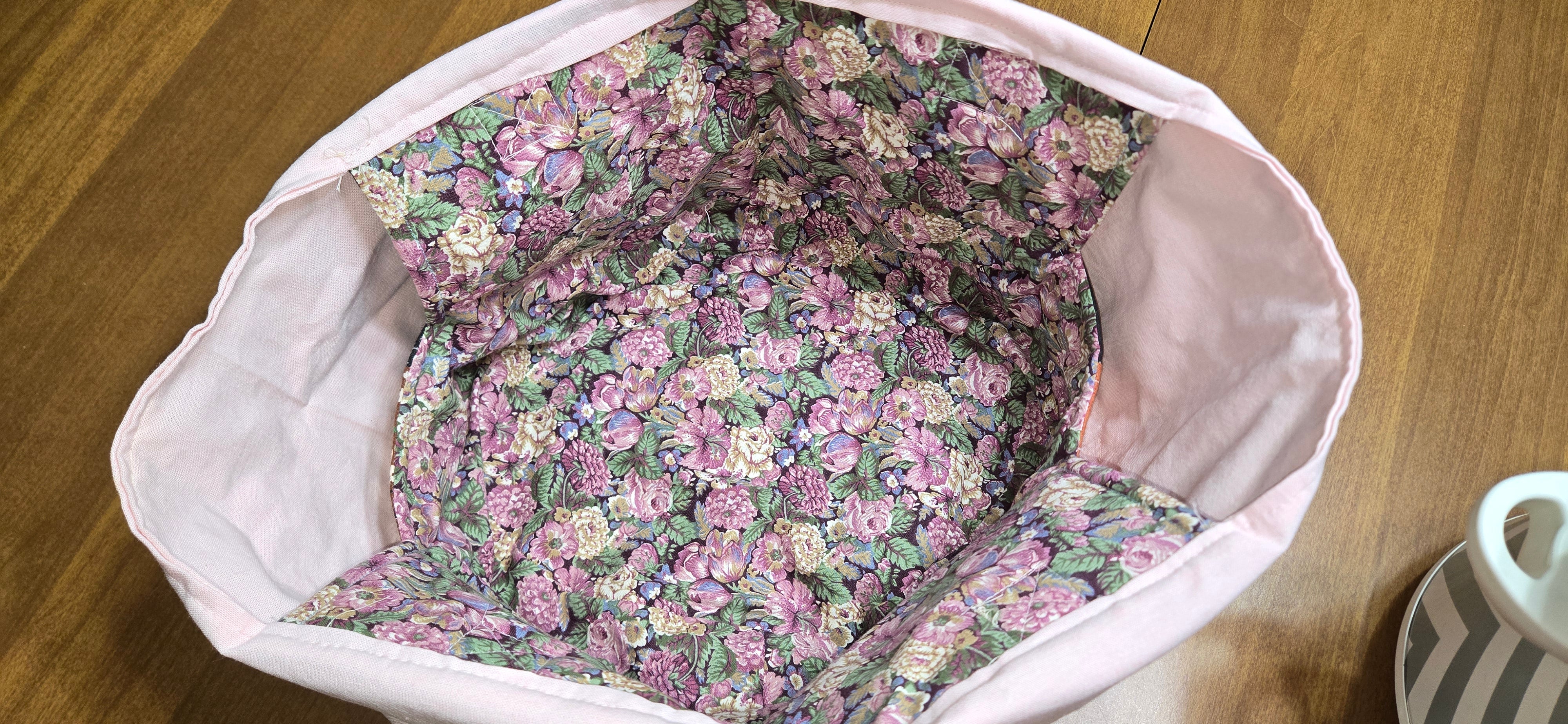 Floral-patterned fabric inside of the slow cooker carrier on a wooden surface.