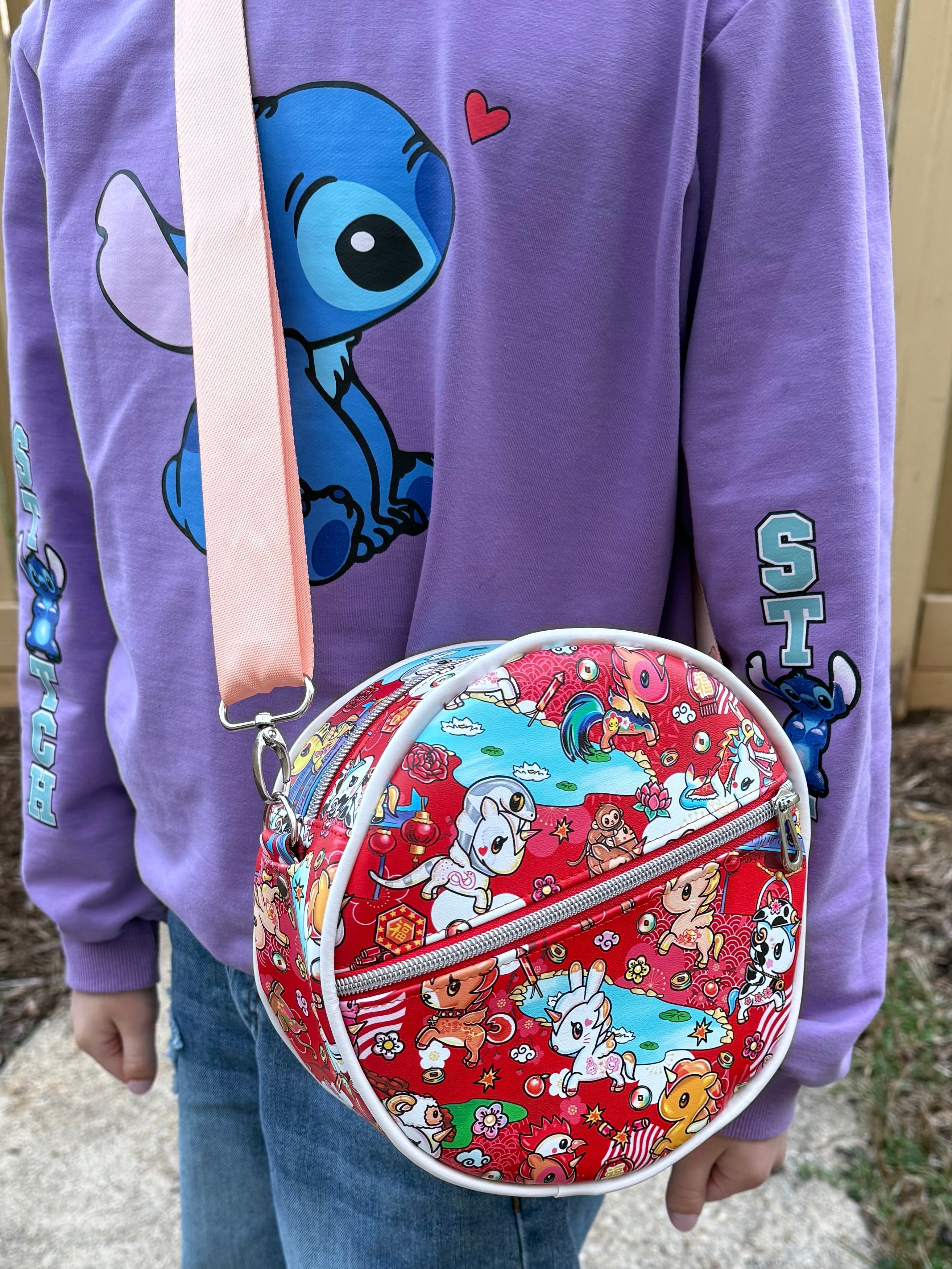 Child holding a red DIY lunch bag with cartoon designs outdoors. Ellie and mac sewing patterns.