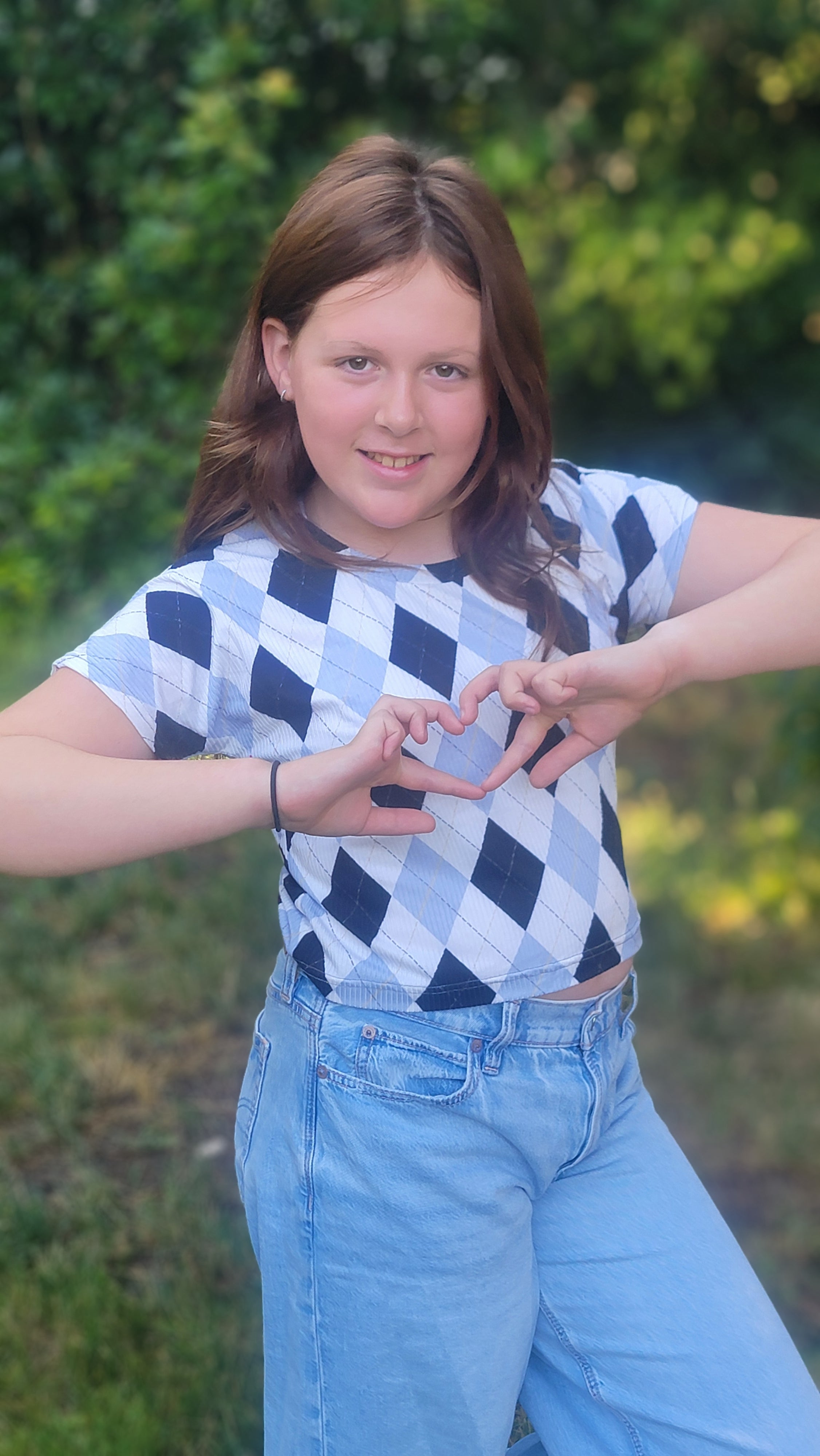 Person wearing a blue and white checkered shirt with a blurred green background