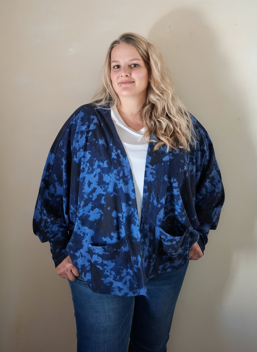 Person wearing a blue camouflage cardigan standing against a plain wall. Soft four way stretch knit fabrics for cardigan sewing pattern used.