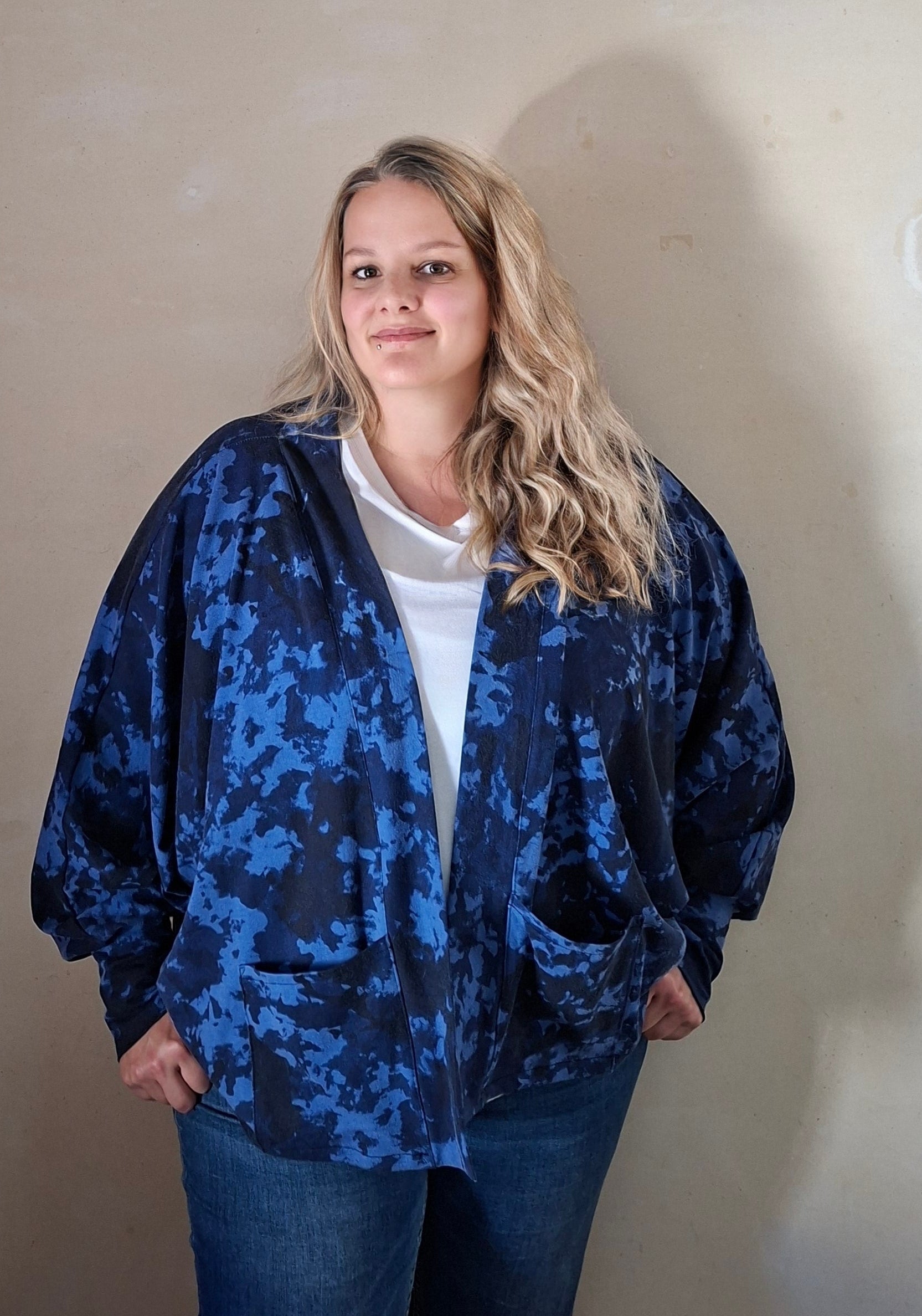 Person wearing a blue camouflage cardigan standing against a plain wall. Soft four way stretch knit fabrics for cardigan sewing pattern used.