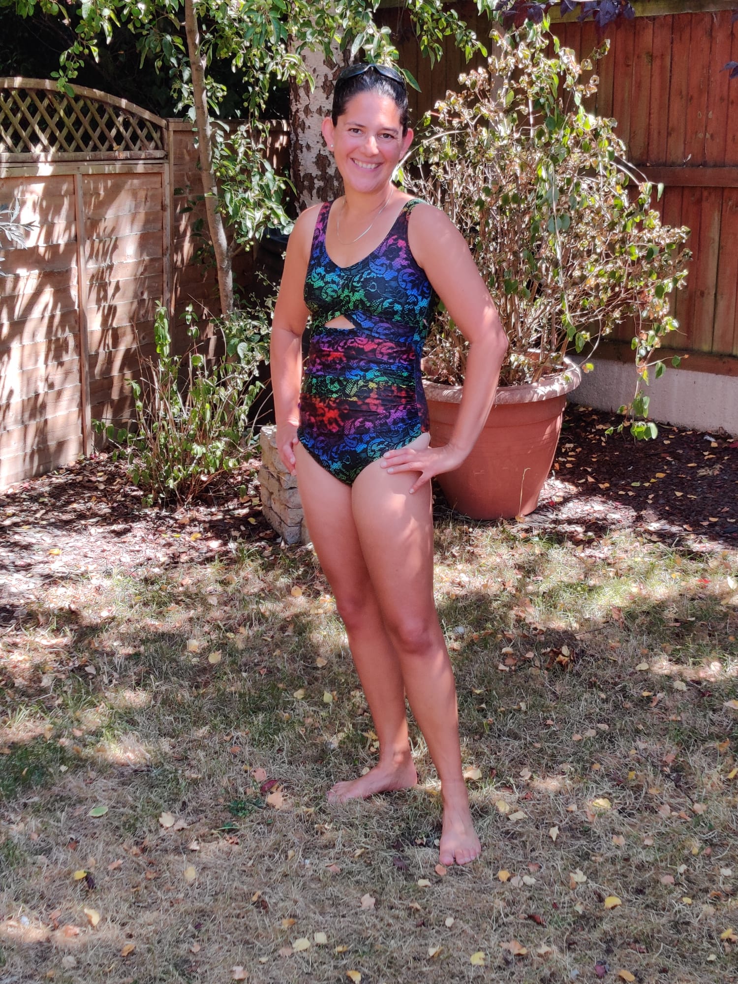 Person wearing a colorful swimsuit standing outdoors in a garden setting.