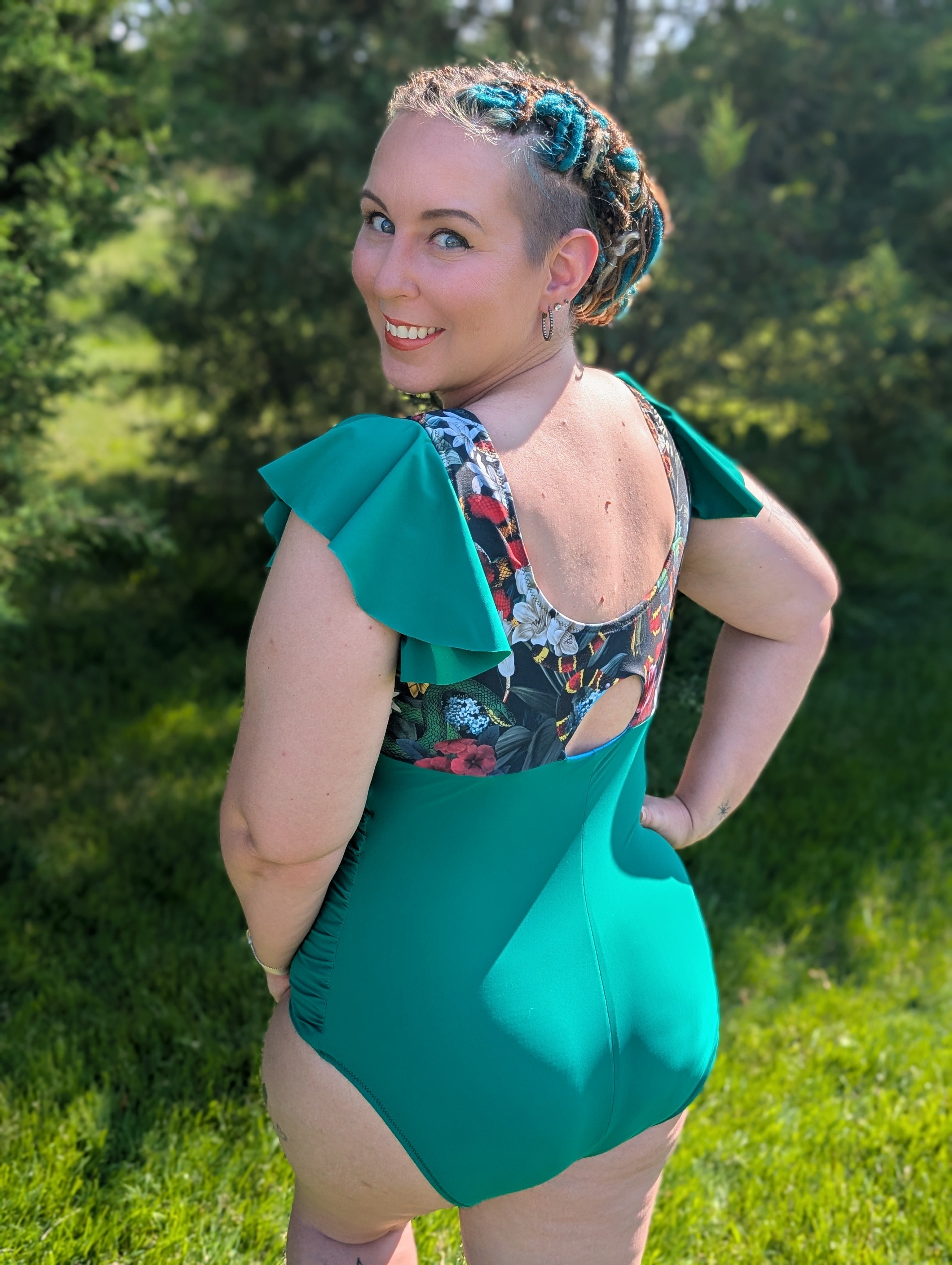 Woman wearing a green swimsuit with floral patterned top in a natural setting