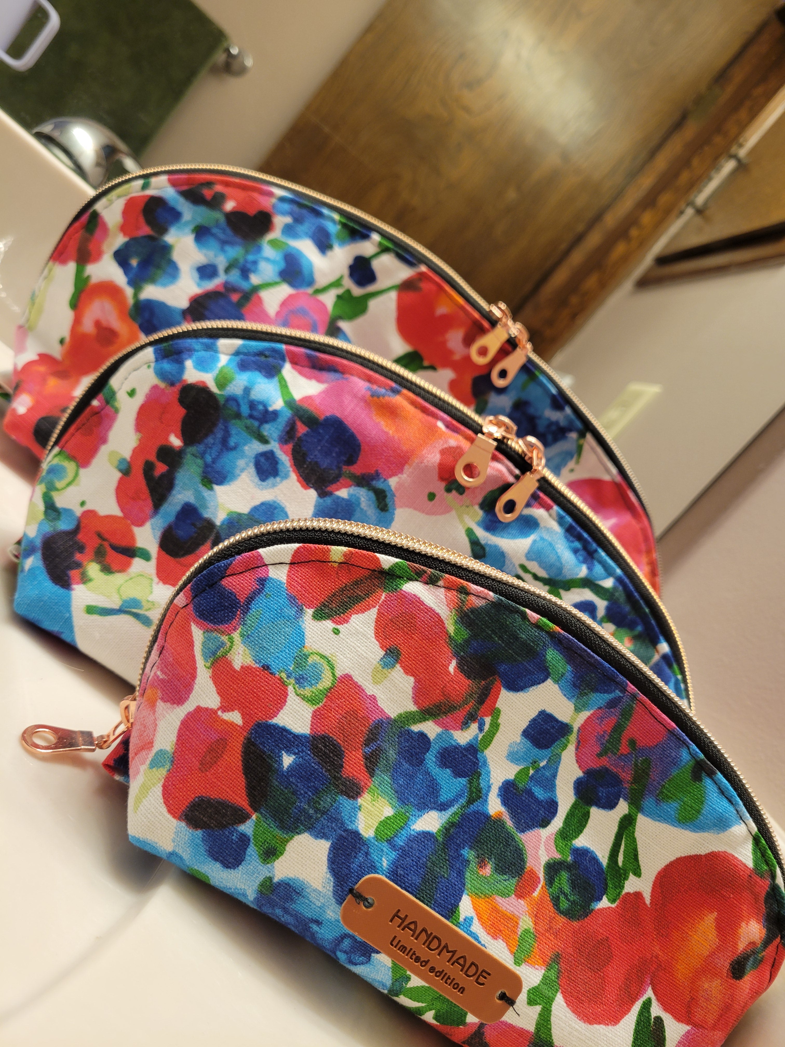 All three sizes of the Tessa Toiletry Pouch displayed together in a styled format.