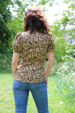 Cheetah print woven wrap top with short puff sleeve on a female model. Easy sewing pattern.
