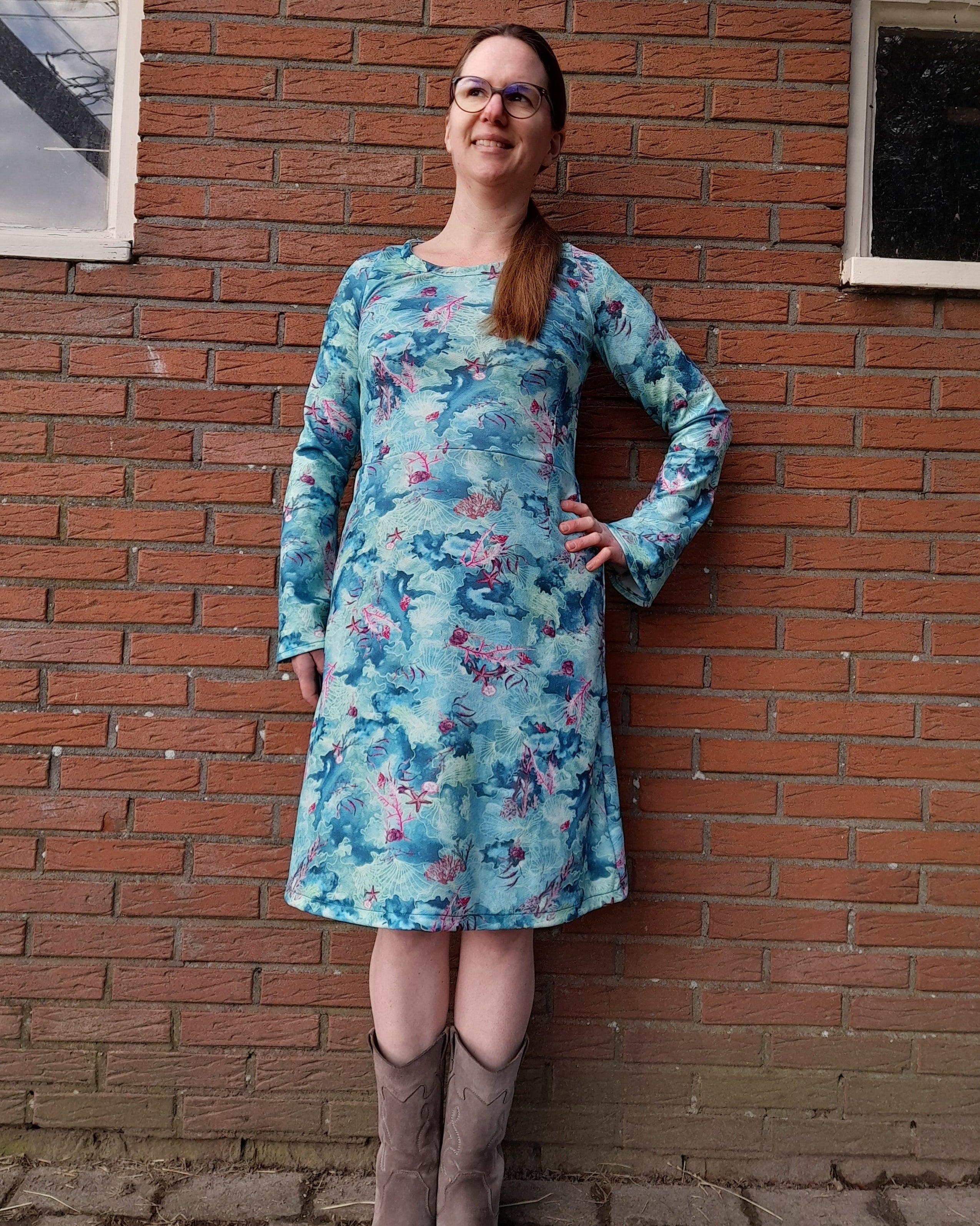 Person wearing a blue floral dress with belle sleeves standing on a brick pavement. Made using Ellie and Mac Sylvie Sewing Pattern