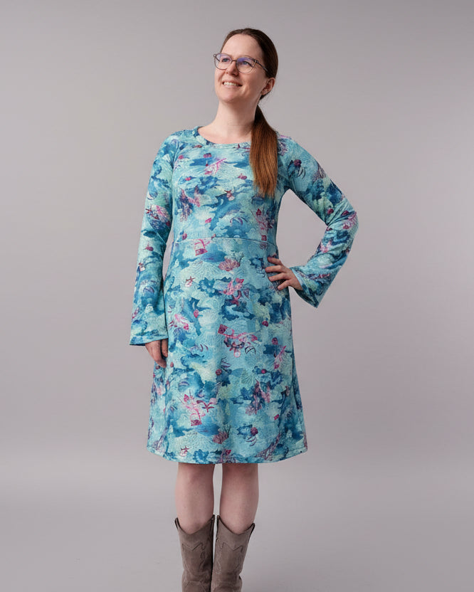 Person wearing a blue floral dress with belle sleeves standing on a brick pavement. Made using Ellie and Mac Sylvie Sewing Pattern
