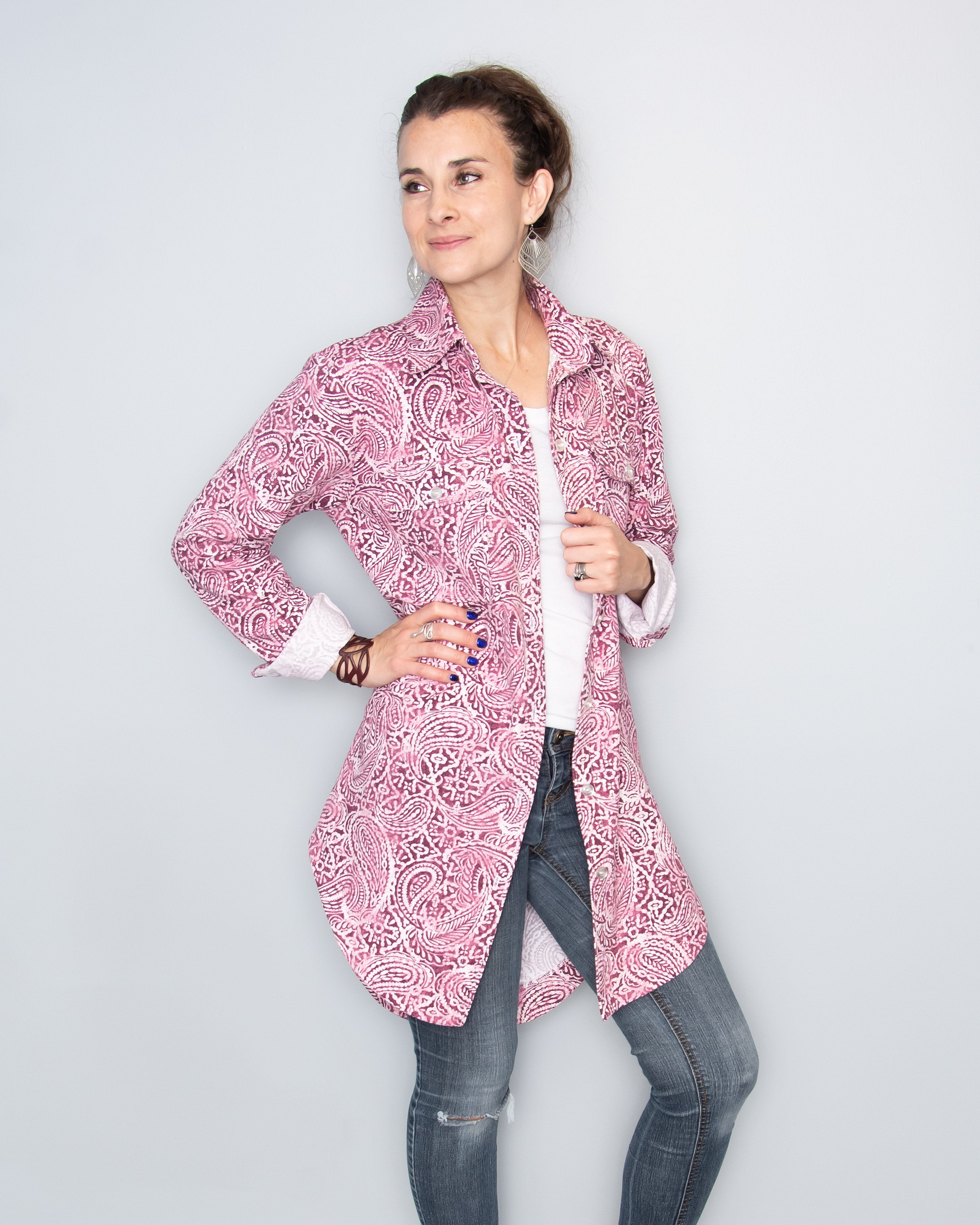 Woman wearing a pink paisley button down shirt open with cuffs rolled up and a white t-shirt underneath. The shirt is made using the Connie Casual Shacket PDF sewing pattern by Ellie and Mac Sewing patterns.