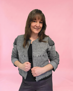 Woman wearing a gray denim jacket against a plain background made using old jeans and the Harper Everyday Jacket sewing pattern.