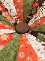 Close-up of a patchwork quilted pillow with floral and geometric patterns. Easy sewing tutorial