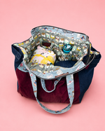 Multicolored bag with a teddy bear and water bottle on a pink background. Made using Ellie and Mac pattern 