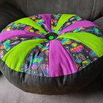 Decorative cushion made with a pdf sewing pattern with colorful mushroom pattern on a couch.