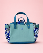 Teal tote bag with floral patterns on a pink background. Emily Oversized Trapeze Tote Bag sewing pattern. 