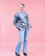 Person wearing a blue patterned jacket and jeans on a pink background. Sizes xxs - 6xl 