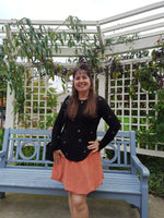 Woman standing outdoors with a blue bench and greenery in the background. Wearing an orange bubble skirt she made using the Sadie Bubble Skirt Pattern.