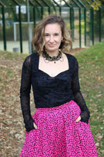 Woman wearing a black top with sweetheart neckline and pink leopard print bubble skirt outdoors. This entire outfit was made using Ellie and Mac's Beginner Friendly sewing patterns. 