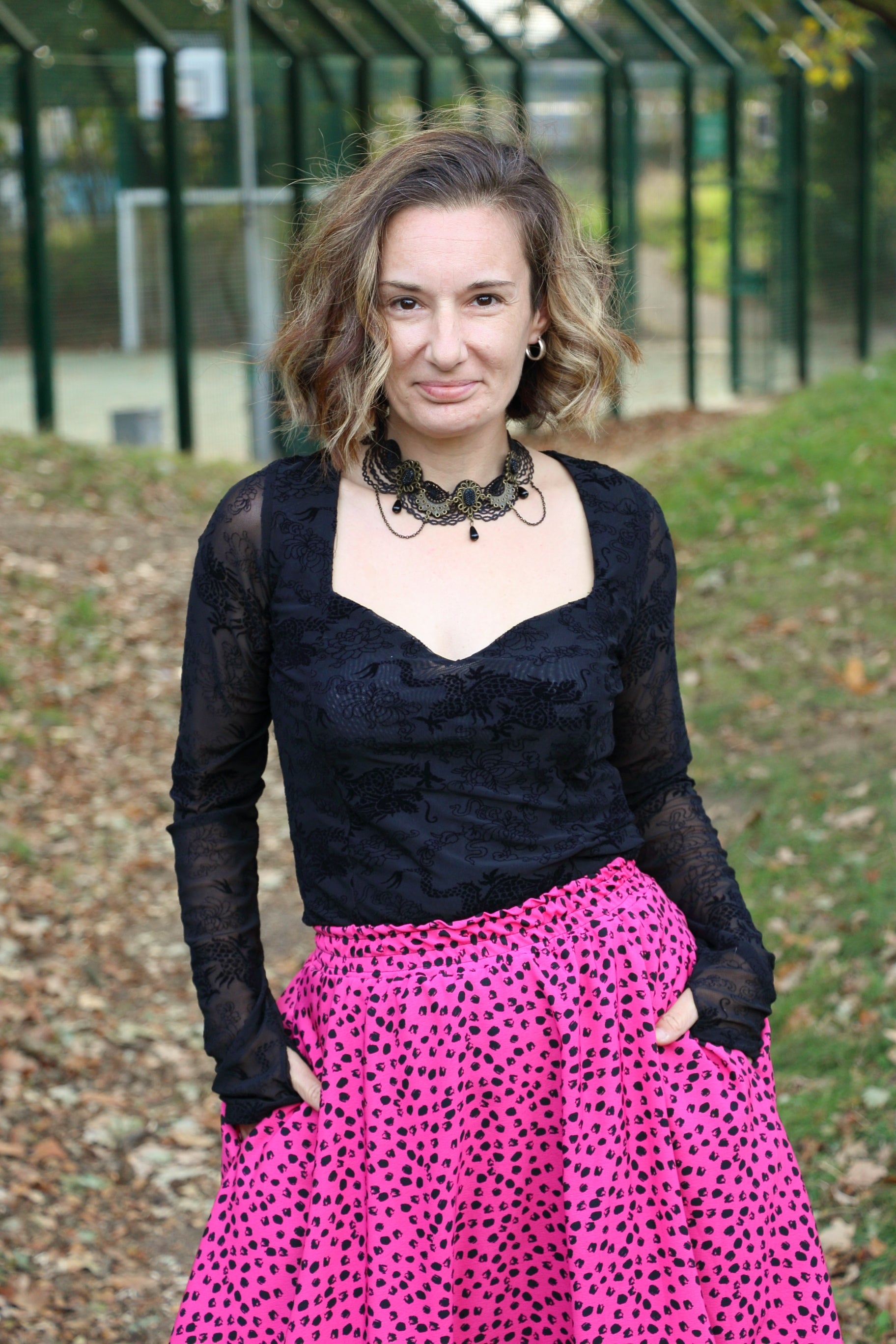 Woman wearing a black top with sweetheart neckline and pink leopard print bubble skirt outdoors. This entire outfit was made using Ellie and Mac's Beginner Friendly sewing patterns. 