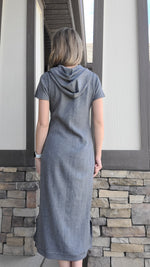 woman wearing a grey sweater dress with hood and short sleeves. Back view showing. 