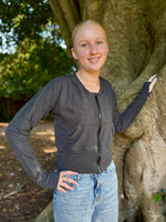 Teen girl outside modeling a solid grey raglan bomber jacket with zip closure, kangaroo pocket detail, and cuffs. diy jacket. 