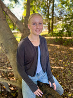 Teen girl outside modeling a solid grey raglan bomber jacket with zip closure, kangaroo pocket detail, and cuffs. diy jacket. 