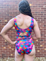 Person wearing a colorful swimsuit with a brick wall background