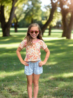 Girl modeling a floral crop top dolman sewing pattern for kids by Ellie and Mac sewing patterns.
