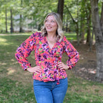 Photo of Lindsey Essary Owner and Head Pattern Designer Ellie and Mac Sewing Patterns standing outside wearing an orange floral Leonie wrap top.