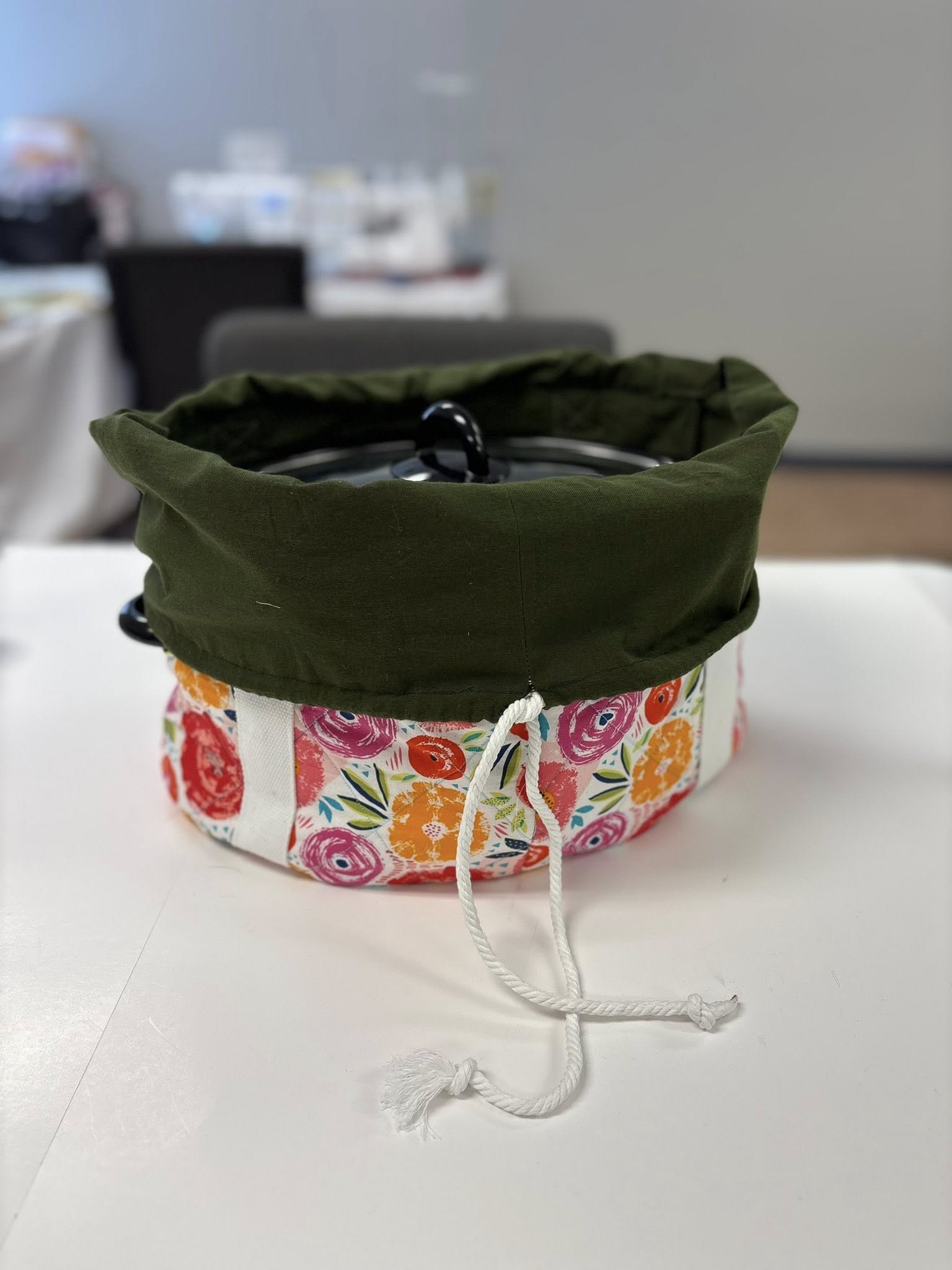 Floral fabric slow cooker carrier bag open to show the pouch folded down over the cooker to allow you to open the lid and serve the food without removing the cooker from the bag. Great for tailgating parties, potlucks, holiday gatherings, and gift giving.