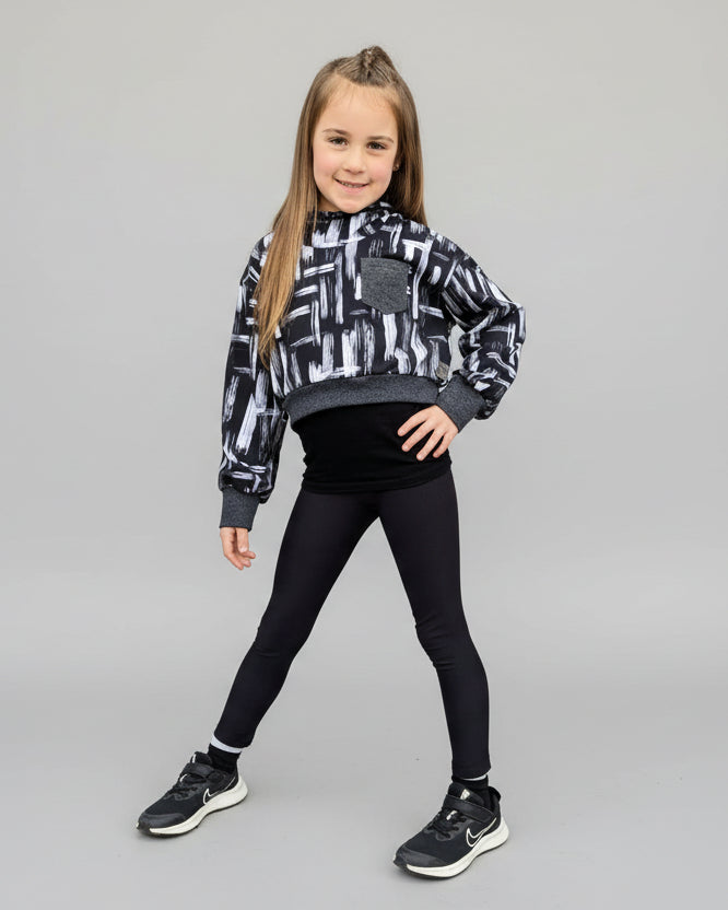 Girl wearing a cropped hooded sweatshirt made using DIY Ellie and Mac patterns