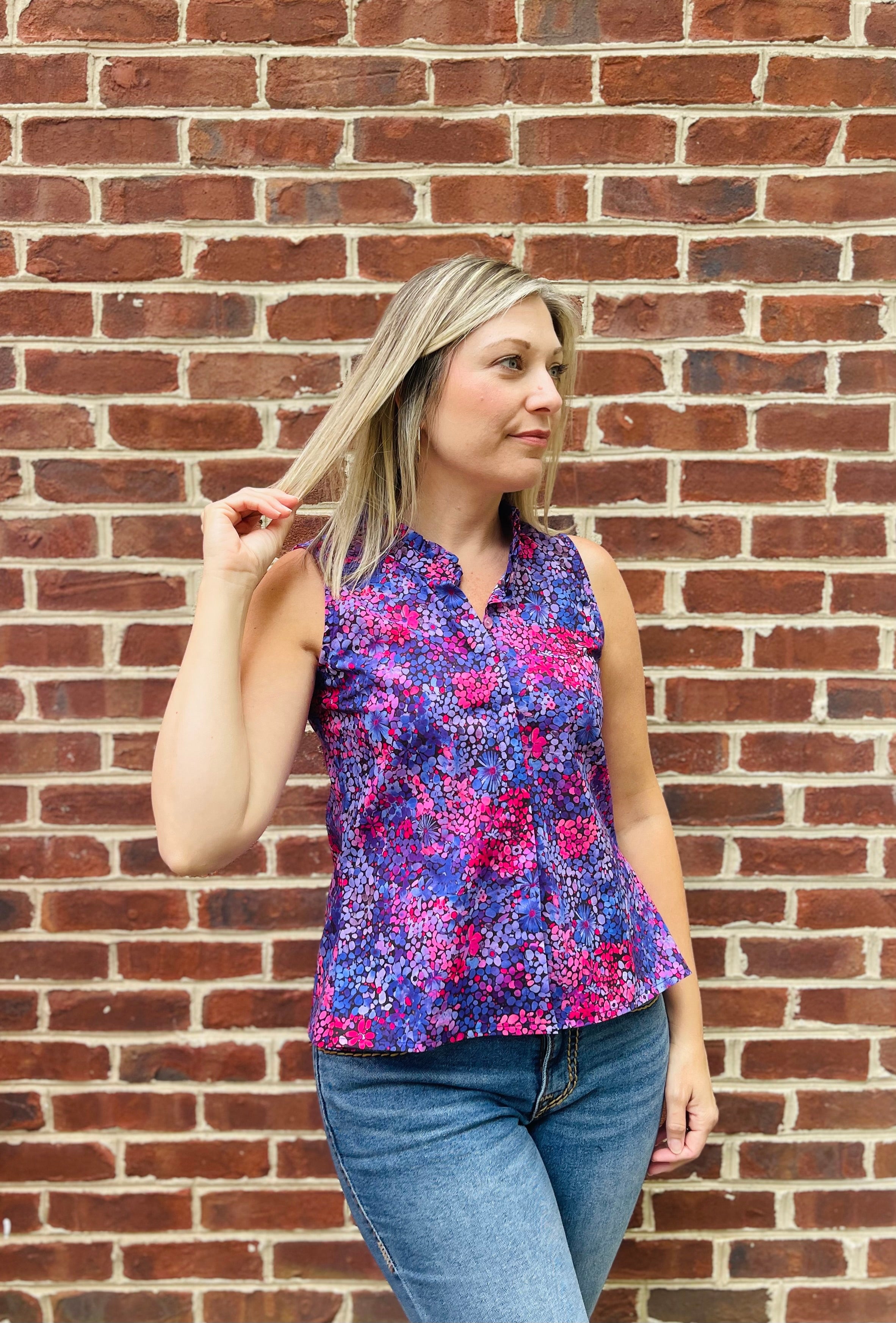 PDF sewing patterns for woven fabrics. Button down sleeveless top modeled by a blond woman. Floral voile fabric. Hidden placket with ruffle collar detail. 