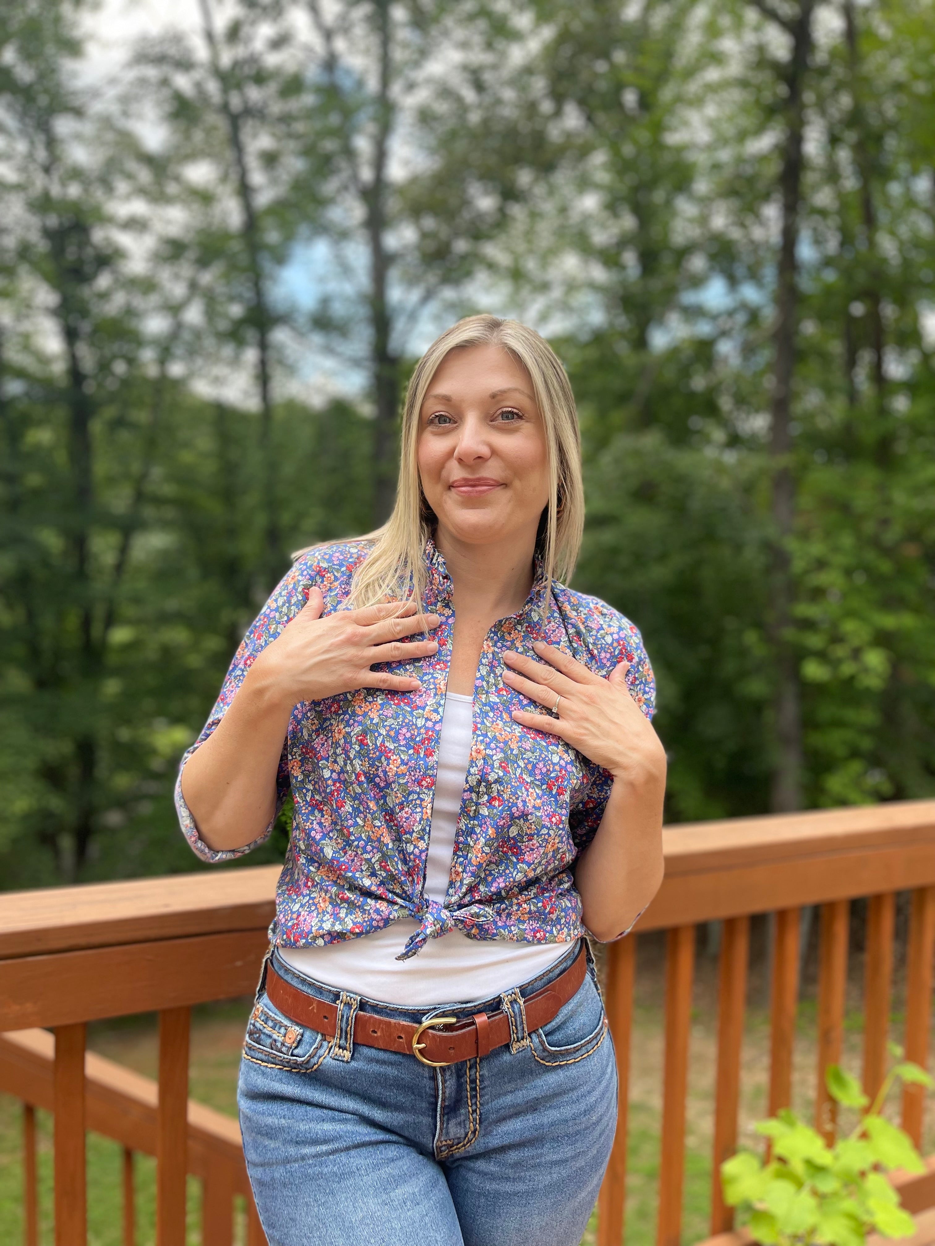 Button Down Hidden Placket Shirt Sewing Pattern by Ellie and Mac sewing patterns. This pattern is modeled on a blond woman with a white cami top and the floral woven  button down top tied in front and the long sleeves rolled up 3/4. 