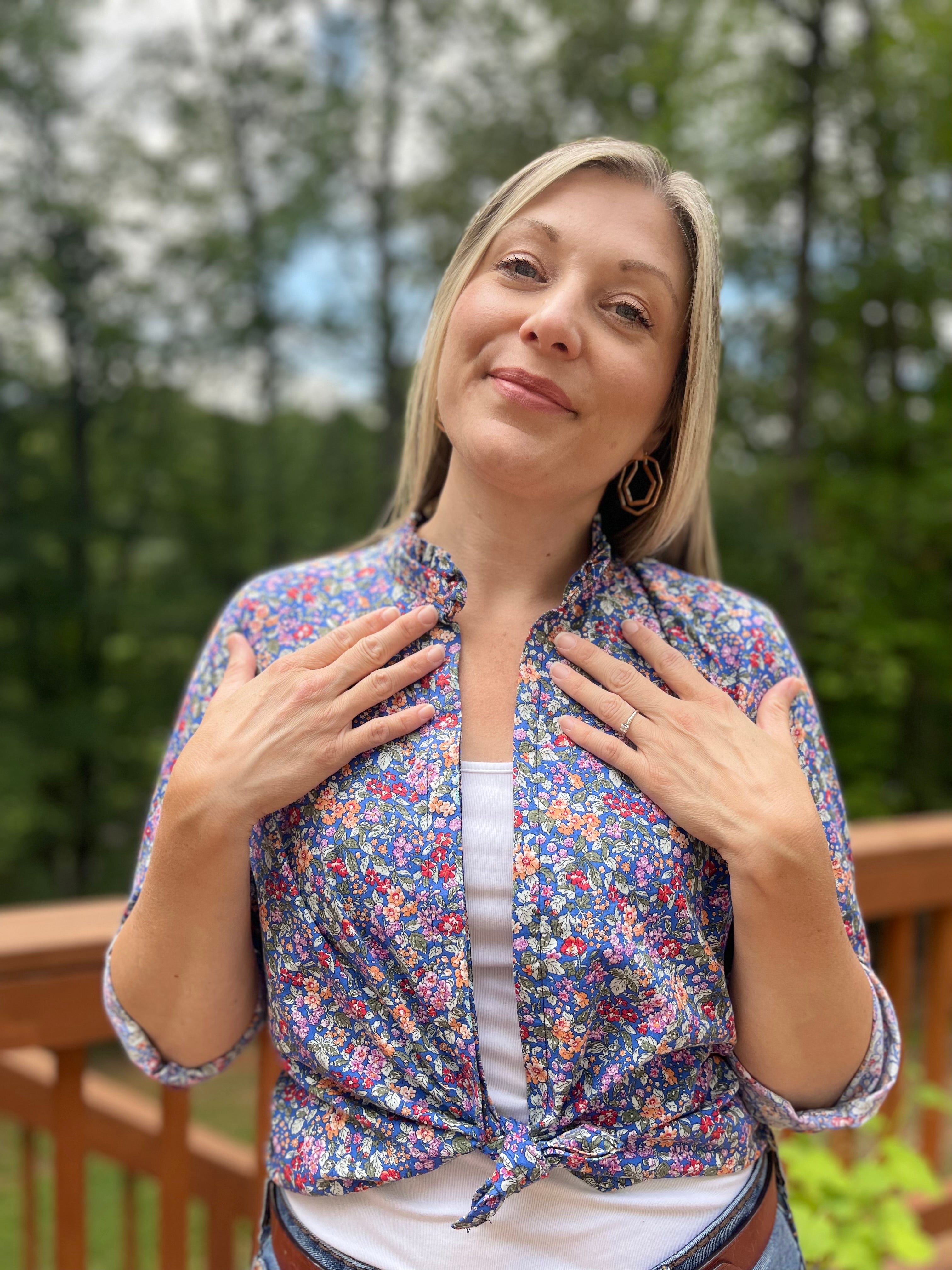 Button Down Hidden Placket Shirt Sewing Pattern by Ellie and Mac sewing patterns. This pattern is modeled on a blond woman with a white cami top and the floral woven  button down top tied in front and the long sleeves rolled up 3/4.  Ruffle collar stand detail. PDF sewing patterns.