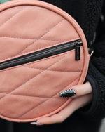 Round pink quilted bag with a zipper held by a person. Made using Ellie and Mac sewing patterns.