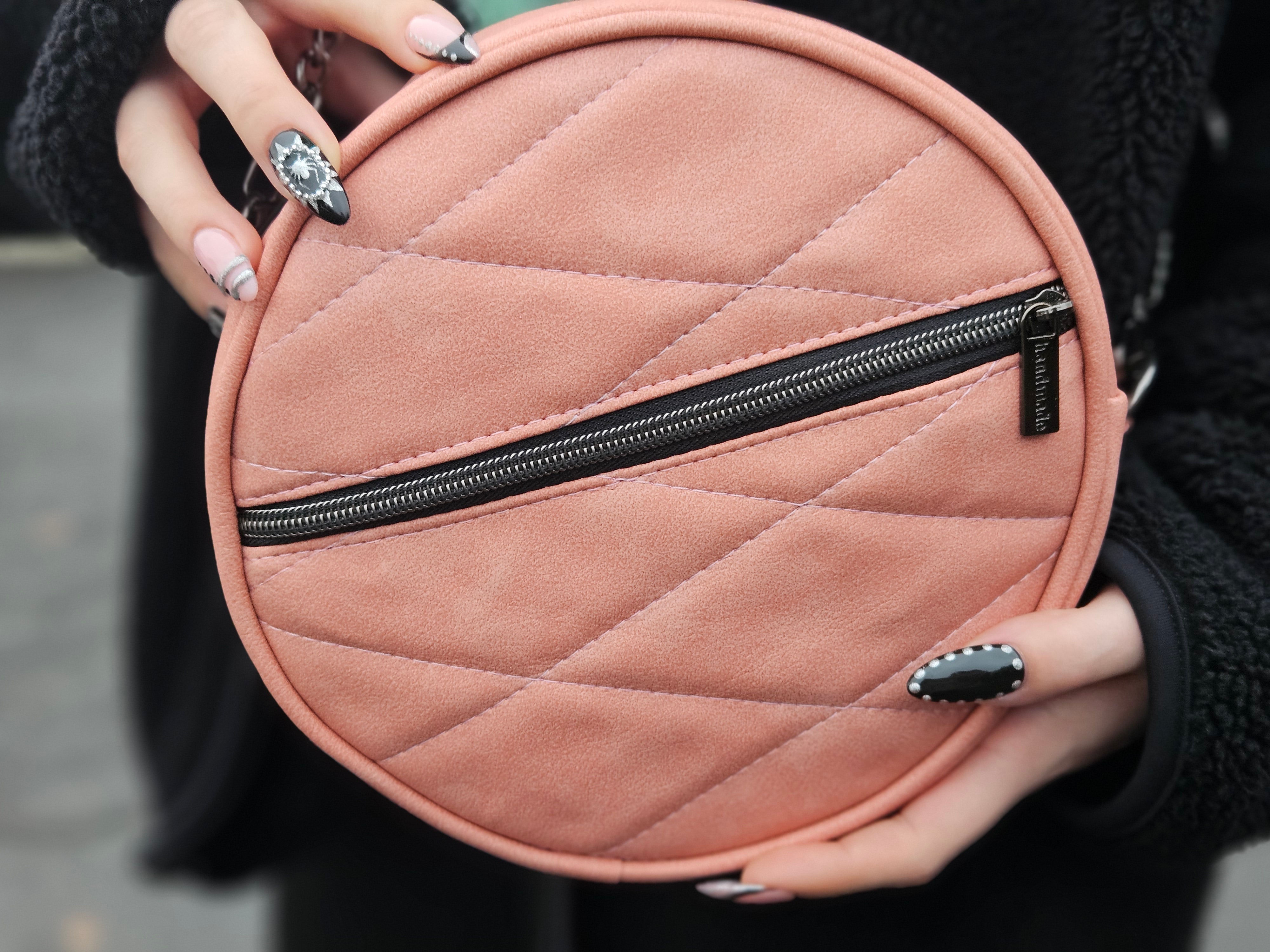 Round pink quilted bag with a zipper held by a person. Made using Ellie and Mac sewing patterns.