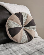Decorative round pillow with geometric pattern on a textured surface. Easy sewing pattern for beginners. Cotton woven scrap fabric pattern.